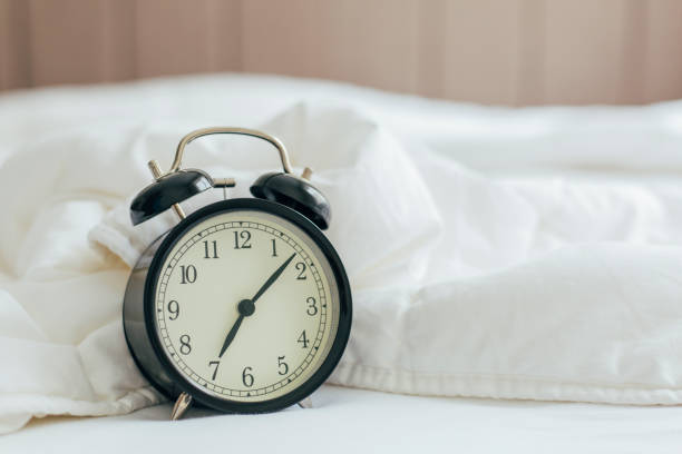 istock Alarm Clock on the White Bed in the Morning 1216931919