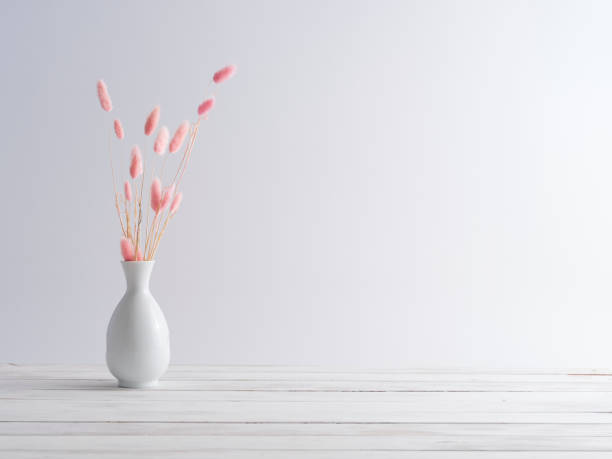 istock Pink bunny tail grass in vase on a white wooden table. 1216931972