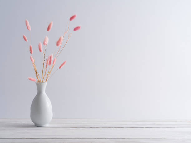 istock Pink bunny tail grass in vase on a white wooden table. 1216932133