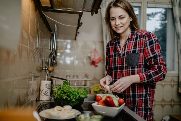 istock Young woman peeling eggs in the kitchen 1216934772