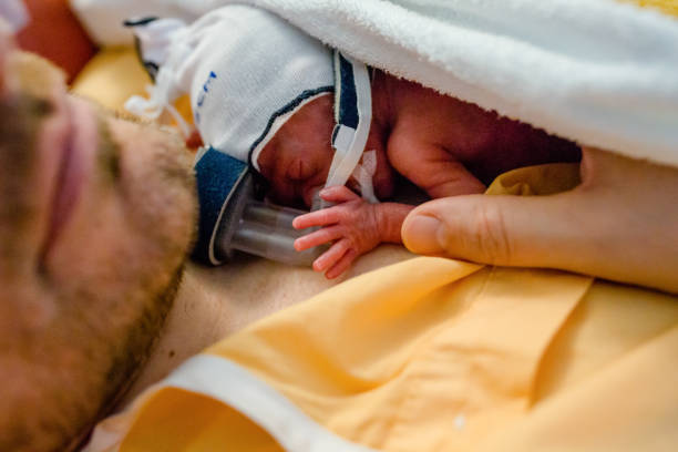 bebé prematuro se acuesta en el pecho de papá - premature fotografías e imágenes de stock