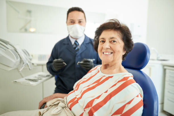 посещение стоматолога для стоматологического лечения - smiling dentist office dentists chair women стоковые фото и изображения