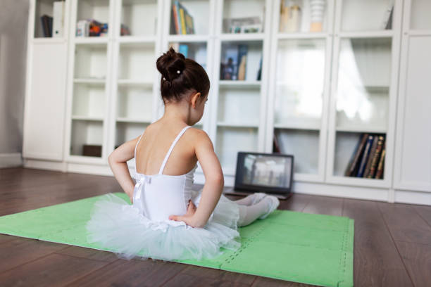 ballerina piuttosto giovane che pratica la coreografia classica durante le lezioni online nella scuola di balletto, distanza sociale durante la quarantena, autoisolamento, concetto di educazione online - art indoors lifestyles education foto e immagini stock