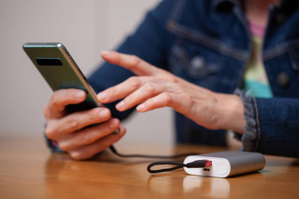 istock Woman hands plugging a charger on a smart phone. 1216941663