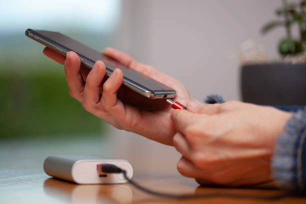 istock Woman hands plugging a charger on a smart phone. 1216941675