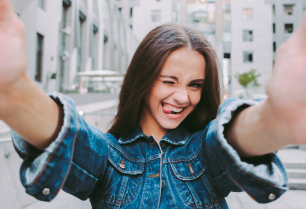 istock Cool happy girl winking and making selfie 1216942093