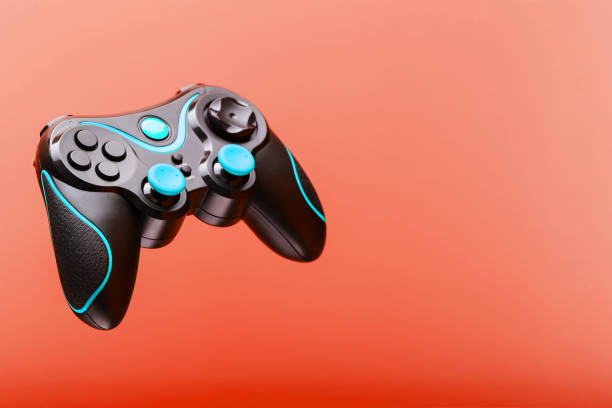 istock Black joystick game controller with blue levitation buttons isolated on pink background. 1216943236