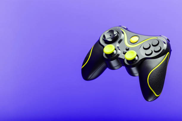 istock Gamepad game controller with yellow buttons on the purple background. 1216943720