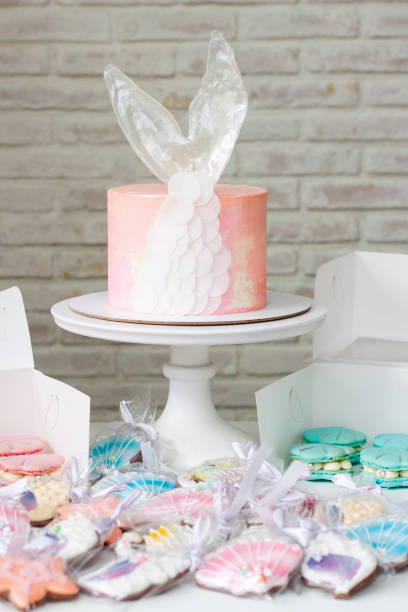 istock Mermaid theme candy bar with cake, cupcakes, macaroons and biscuits. Sea shell shaped macaroons with pearls. 1216943749