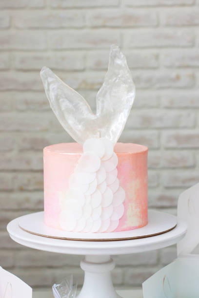 istock Mermaid theme candy bar with cake, cupcakes, macaroons and biscuits. Sea shell shaped macaroons with pearls. 1216943891