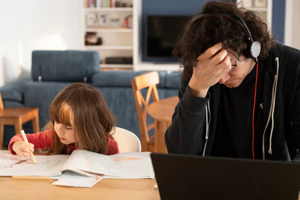 Father working at home with little daughter during covid-19 lockdown.