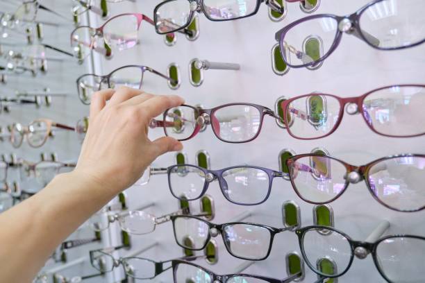 istock Showcase with glasses in the store, hand choosing glasses 1216950472