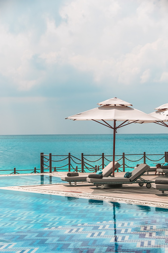 Tropical Swimming Pool in Maldives with sunbeds and wooden deck