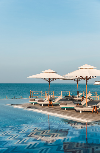Sun loungers by the swimming pool in luxury hotel resort