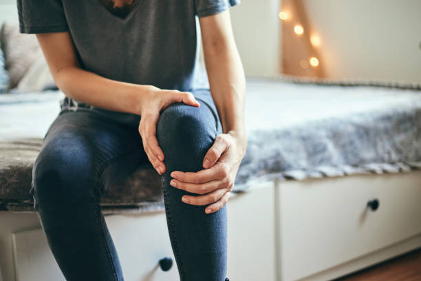 Woman suffering from knee pain. stock photo