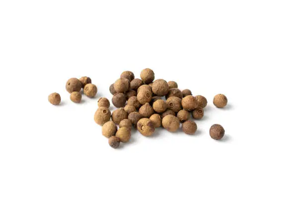 Pile of allspice isolated on white background top view. Jamaica pepper, allspice peppercorns or myrtle pepper close up