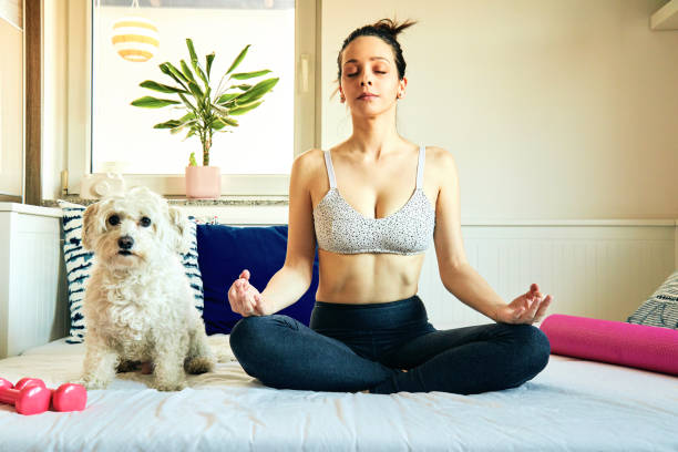 istock Attractive fit woman doing workout/ meditate at home with dog. 1216953732