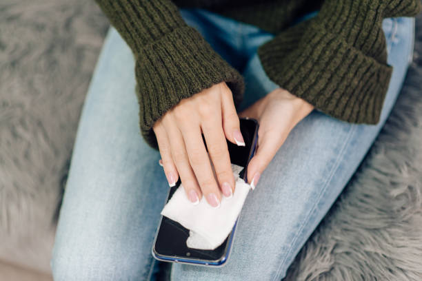 istock Young woman sanitizing her smart phone 1216954035
