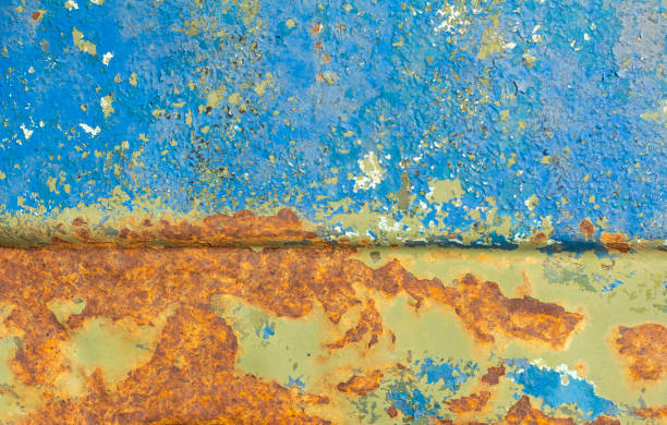 istock An old metal case with bright orange spots of rust through several layers of paint.Peeling paint on old rusty metal. 1216958143