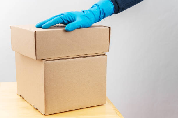 istock Contact less delivery concept, safe shipment, courier in a protective rubber gloves with carboard box, order from online shop. 1216958227