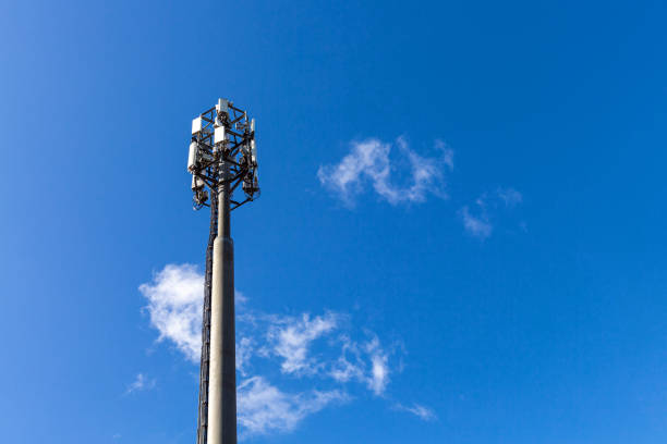 Telecommunication tower with microwave equipment, radio panel antennas, outdoor remote radio units, power cables, coaxial cables, optic fibers, climatic vandal-proof cabinets are installed on the mast torre de telecomunicaciones con equipos de microondas, antenas de paneles de radio, unidades de radio remotas al aire libre, cables de alimentación, cables coaxiales, fibras ópticas, gabinetes a prueba de vandalería climática están instalados en el m�