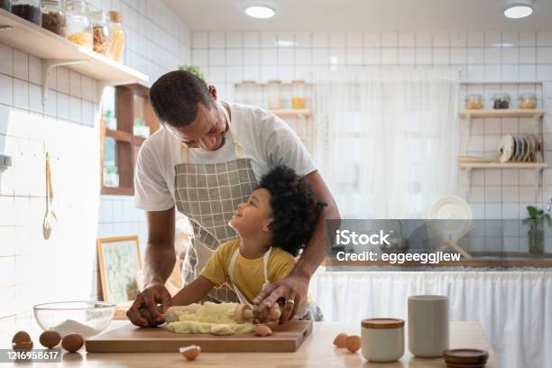 Happy Smiling African Family In Aprons Cooking And Kneading Dough On Wooden  Table Stock Photo - Download Image Now - iStock