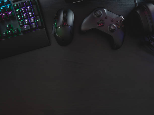 istock gamer work space concept, top view a gaming gear, mouse, keyboard, joystick, headset, mobile joystick, in ear headphone and mouse pad on black table background. 1216959473