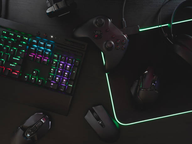 istock gamer work space concept, top view a gaming gear, mouse, keyboard, joystick, headset, mobile joystick, in ear headphone and mouse pad on black table background. 1216959479