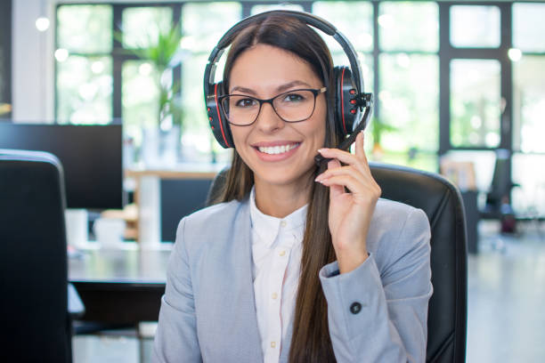 istock Friendly female helpline operator with headset in office 1216961634