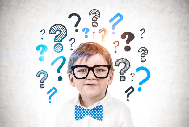 istock Cute little boy in glasses, question marks 1216962181