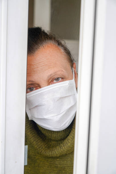 istock old woman looking out the window. 1216963170