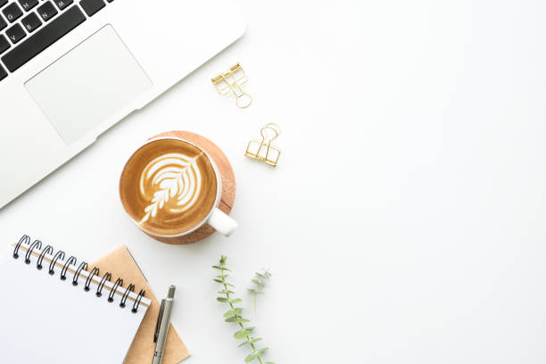 istock White hipster office desk table with laptop computer, cup of latte coffee, notebook with pen and supplies. Top view with copy space, flat lay. 1216964634