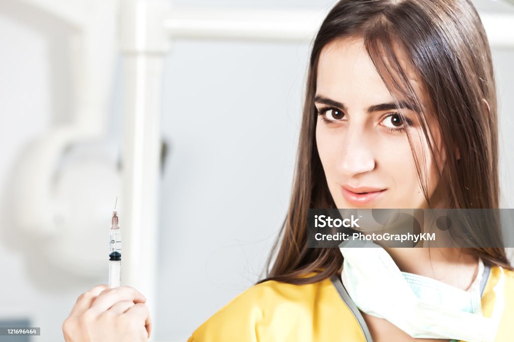 Hermoso dentista sostiene una inyección - Foto de stock de Acero libre de derechos