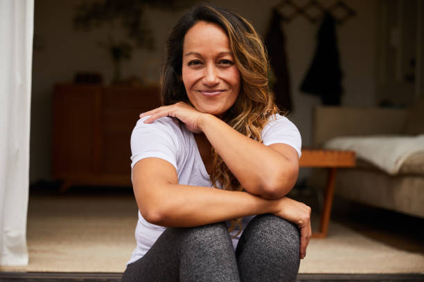 istock Mature woman smiling while sitting on her patio steps 1216965079