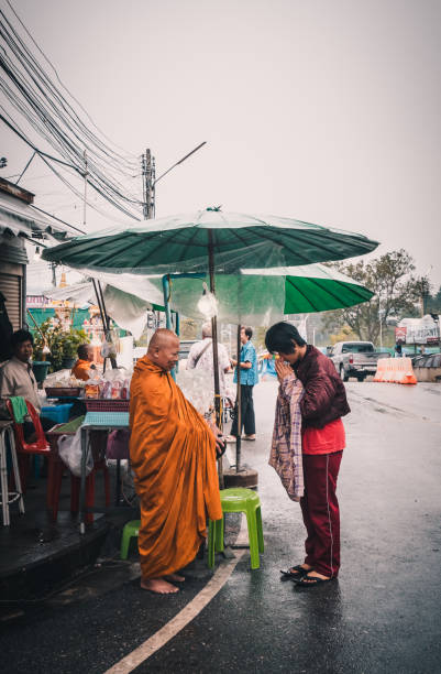 Ratchaburi,Thailand - November 6, 2017 : Monk walking along road to alms round in raining day