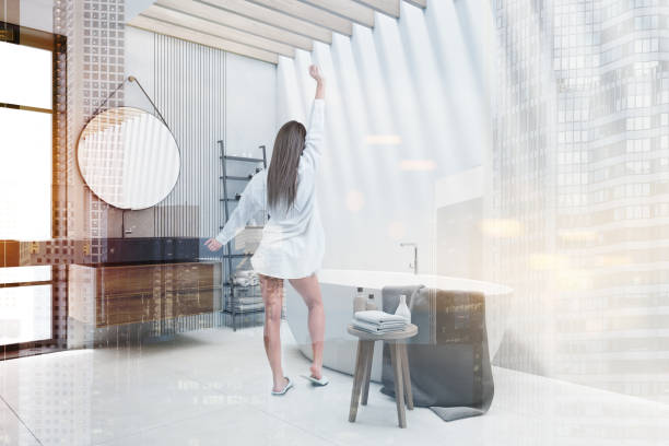 istock Woman in white bathroom with round mirror 1216966372