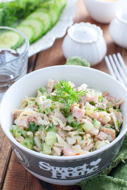 istock Smoked chicken salad with fresh cucumber in a white bowl, selective focus 1216968556