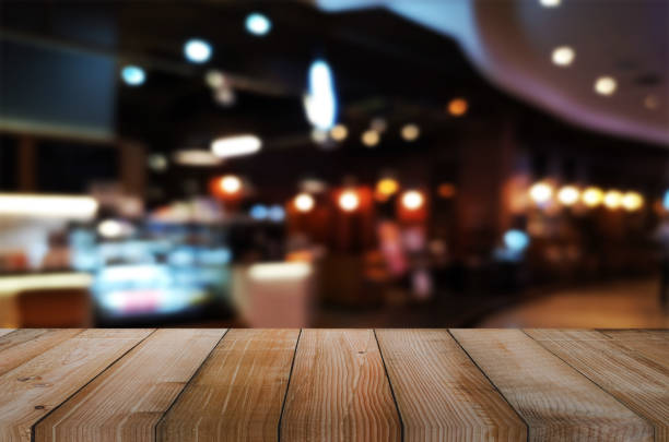 istock wooden table with abstract blurred background resturant lights used for display montage products mock up design. 1216968617