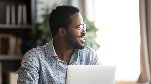 istock Happy young mixed race man distracted from job, looking aside. 1216968852