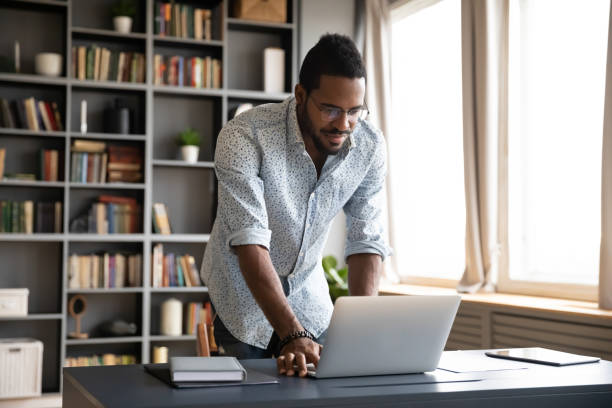 istock Happy young biracial freelance man working standing at table. 1216968857