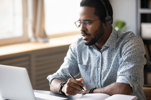 istock Focused young african american man watching educational lecture online. 1216968871