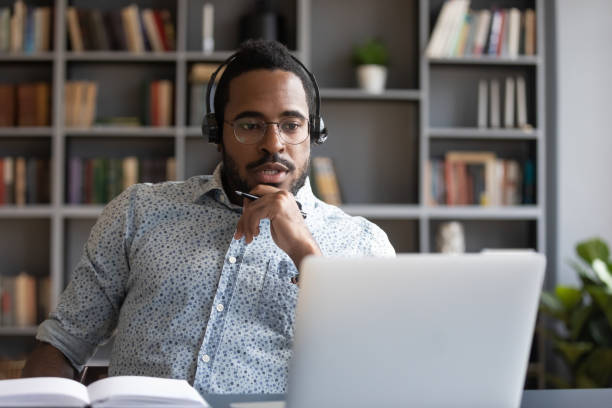 istock Focused millennial mixed race guy consulting clients online. 1216968885