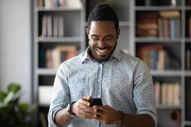 istock Happy african ethnicity guy web surfing information or shopping. 1216969020