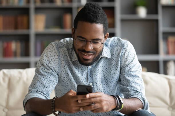 istock Happy biracial guy playing online game on mobile phone. 1216969449