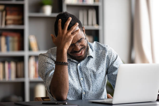 istock Stressed young african american man touching forehead, suffering from headache. 1216969456
