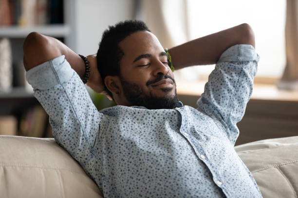 istock Peaceful carefree biracial guy alone napping on couch indoors. 1216969458
