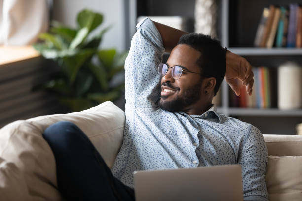 istock Smiling peaceful handsome african american guy visualizing future at home. 1216969473