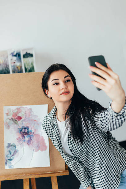 istock Young artist taking selfie with watercolor artwork 1216970202