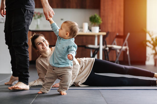 istock Mother doing side leg raises while father with baby walks around 1216971799