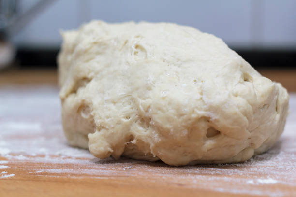 istock Raw dough on wooden board 1216972401